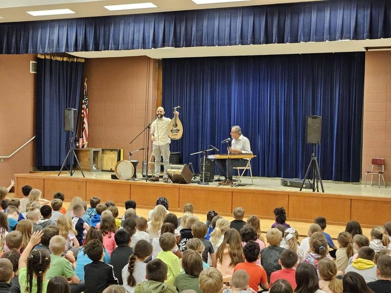  musicians stand on stage and present to 40 elementary school students 