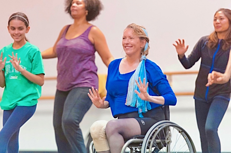  multigenerational and racially diverse group of four smiling dancers including Ladonna in her wheelchair 