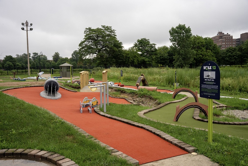  A miniature golf course with a red walking path. 