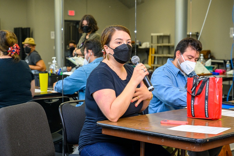 A person with a face mask talking through a microphone. 