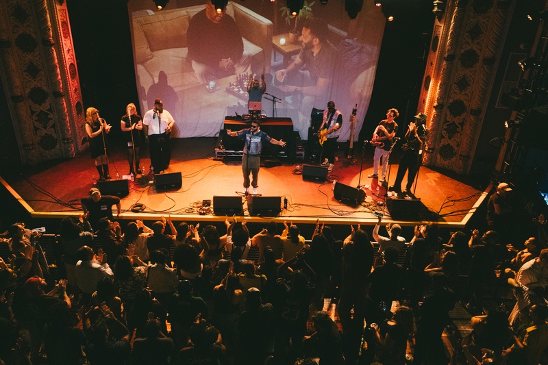  band on stage performing to large crowd 