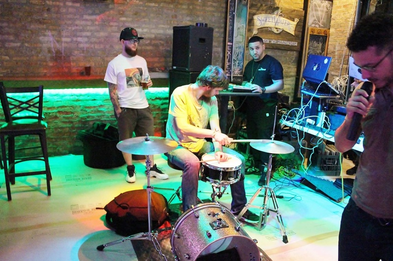  Tommy playing drum set with other band members surrounding 