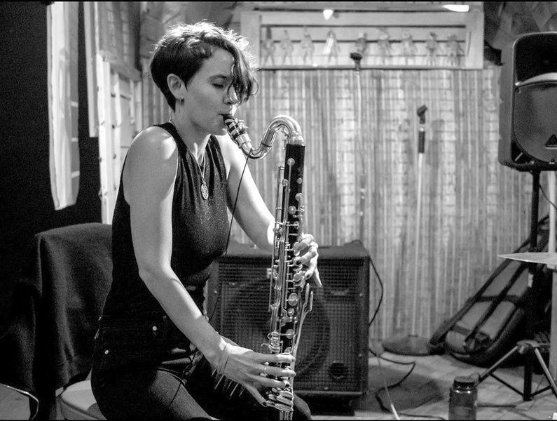  black and white photo of person playing bass clarinet 