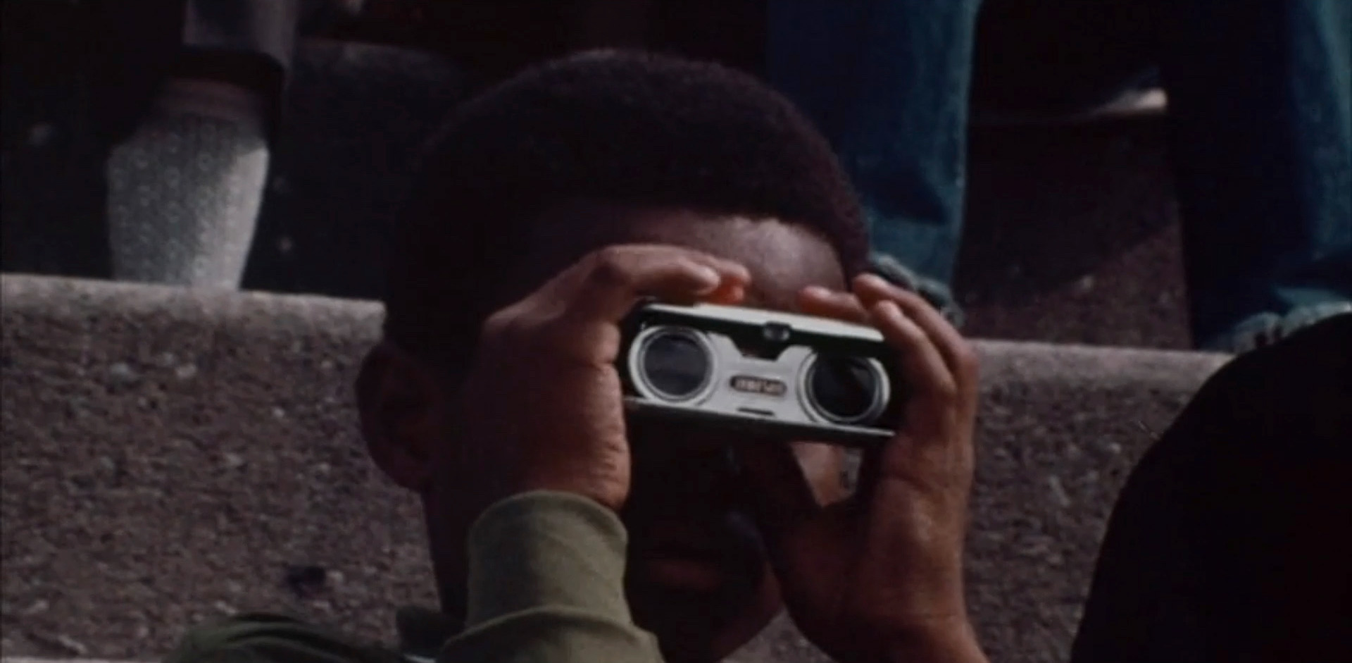 Image of a young Black child holding a viewfinder.
