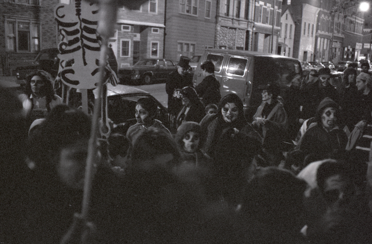 Black and white image of people gathered for the Dia de Los Muertos parade.