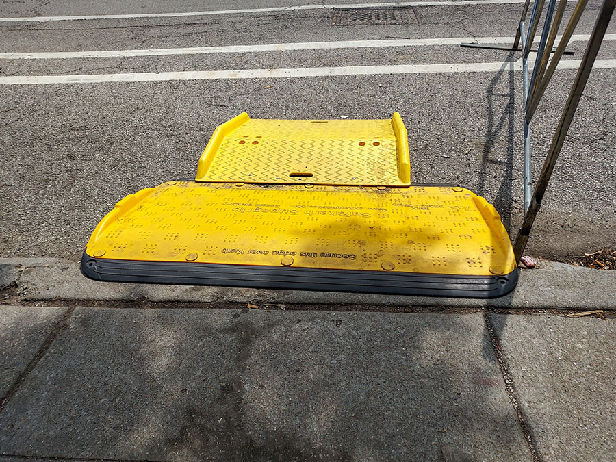 A yellow ramp from a street to a sidewalk
