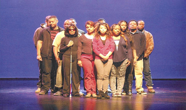 A cast poses on stage.