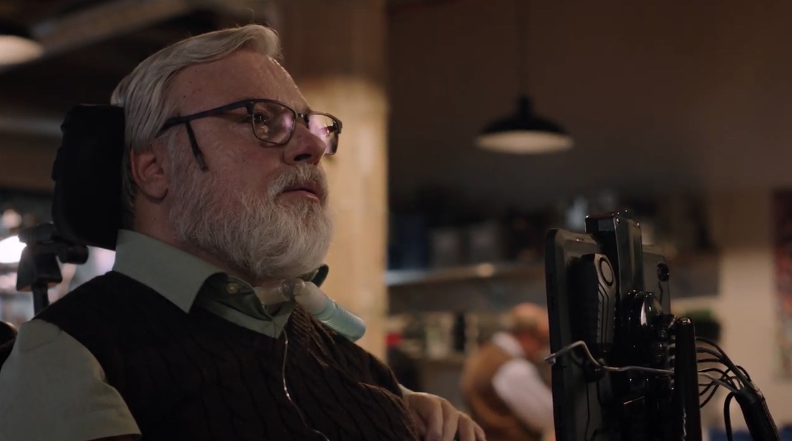 Michael in glasses and an electric chair with an attached computer